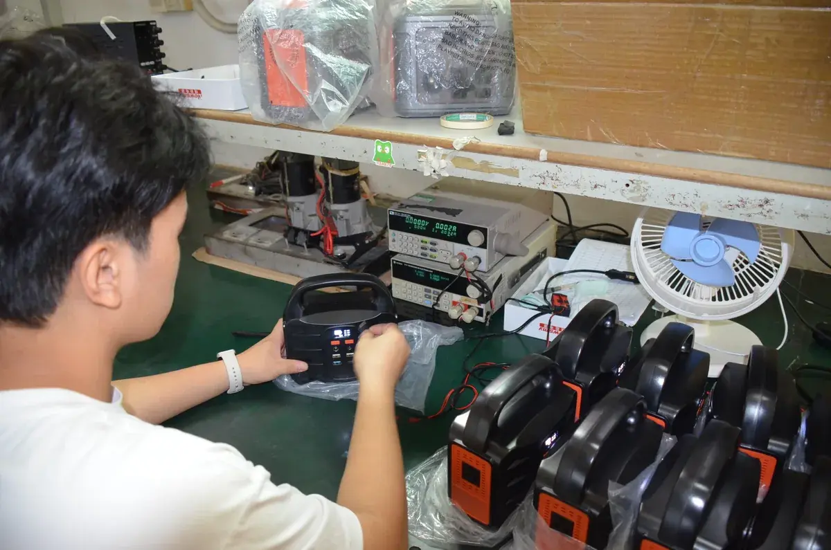 Worker checking a portable power station with electrical test equipment